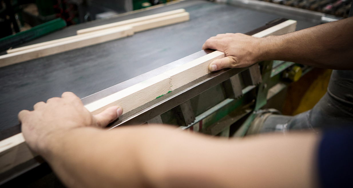 Employee handling 2 pieces of wood on his work surface