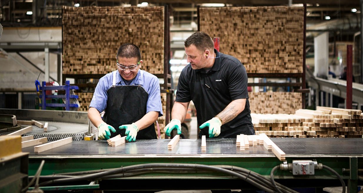 Two Prolam employees sorting wooden boards