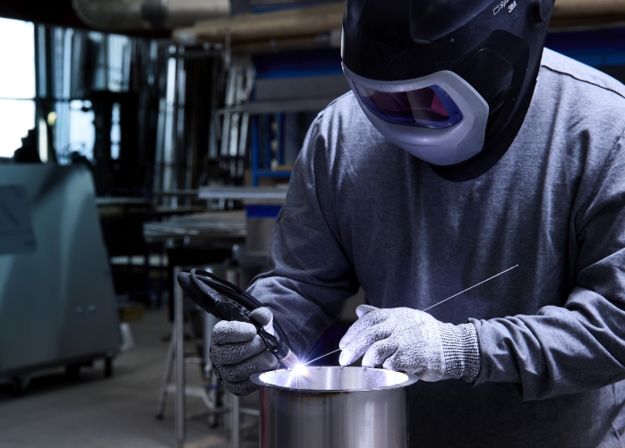 Welder working on a piece of stainless steel